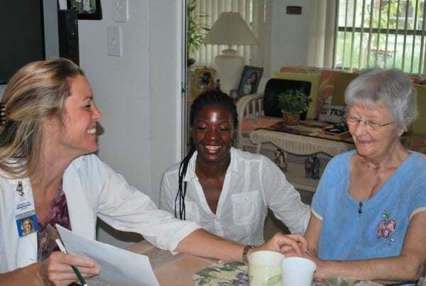 Two caregivers with elderly patient at her home