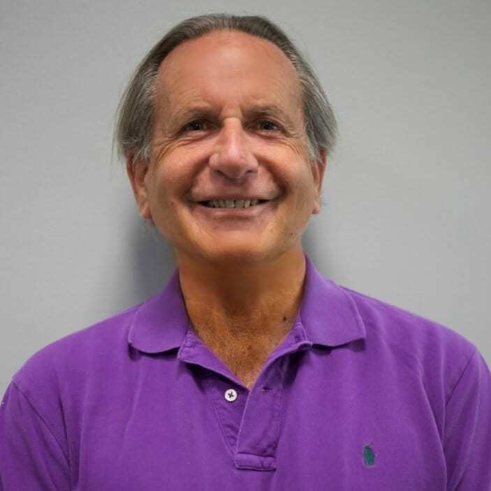 An older man with a purple polo