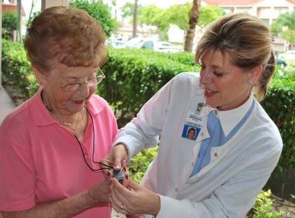 A doctor demonstrating a medical alert system to patient