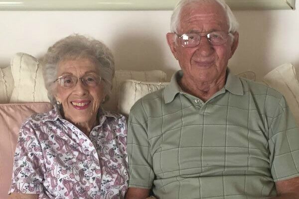 An elderly couple sitting together on a couch