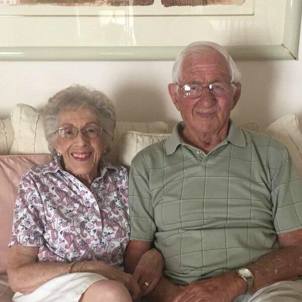 An elderly couple sitting together on a couch