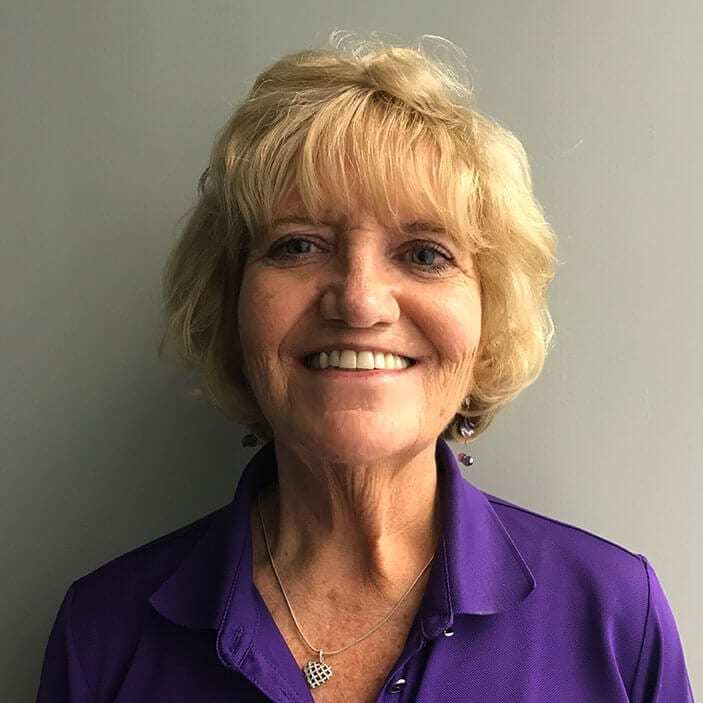 A woman with blonde hair and a purple blouse