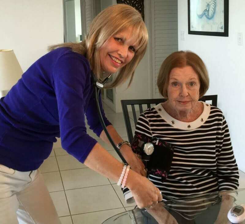 Caregiver taking the blood pressure of elderly patient