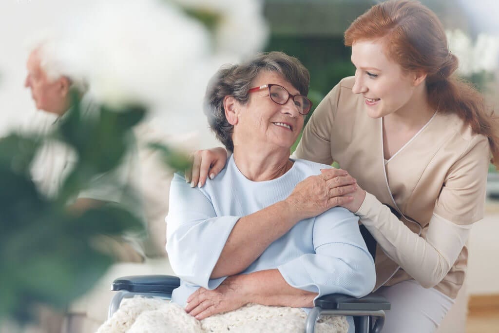 Senior citizen in wheelchair and caregiver