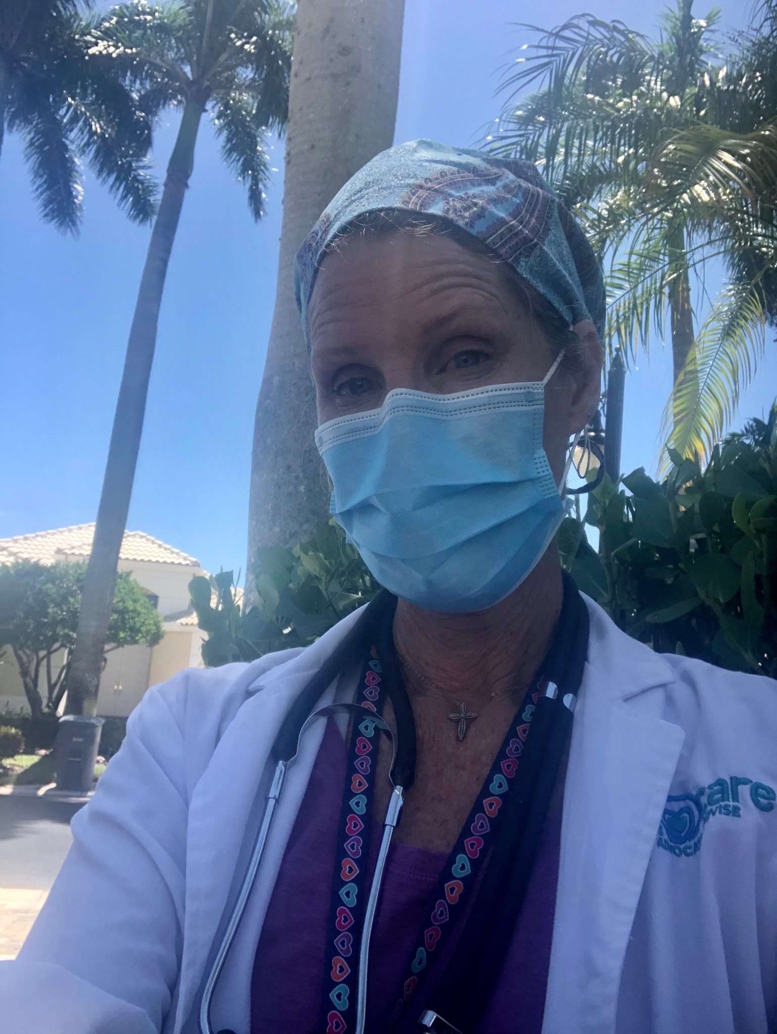 female doctor taking selfie by wearing mask and setscope on her neck