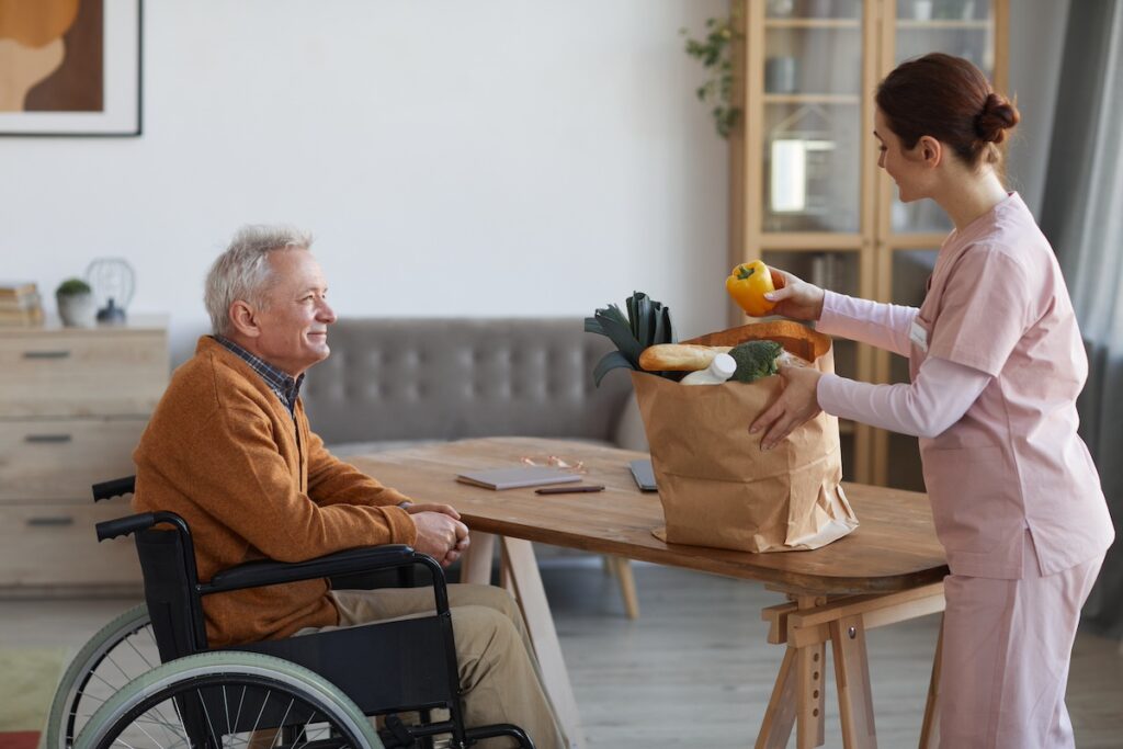 A caregiver helping an elderly man.